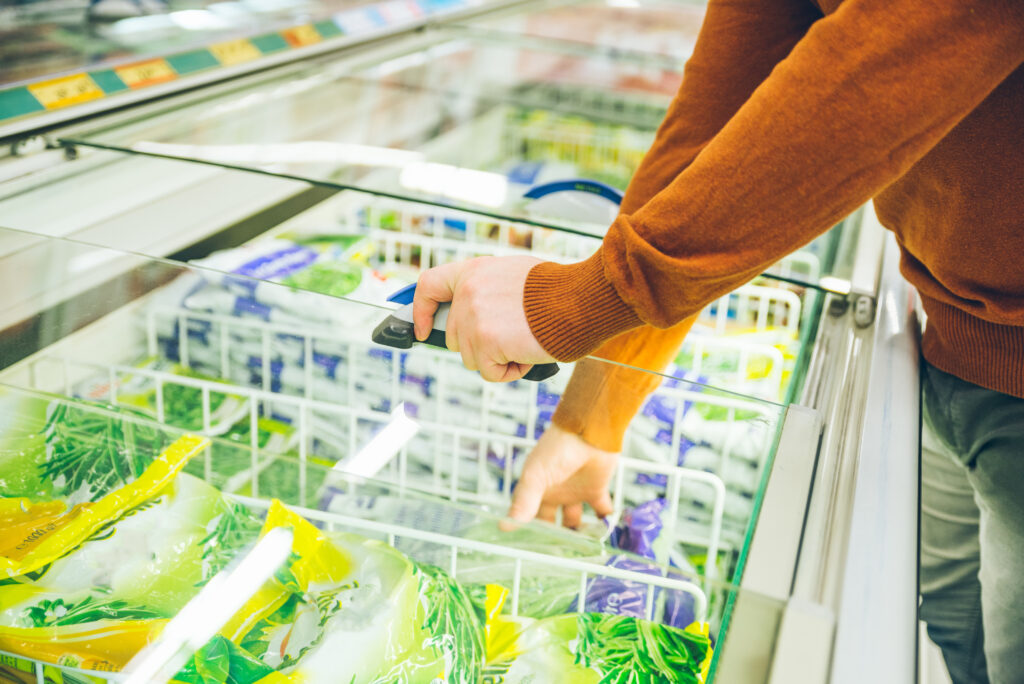man get frozen food from fridge in store